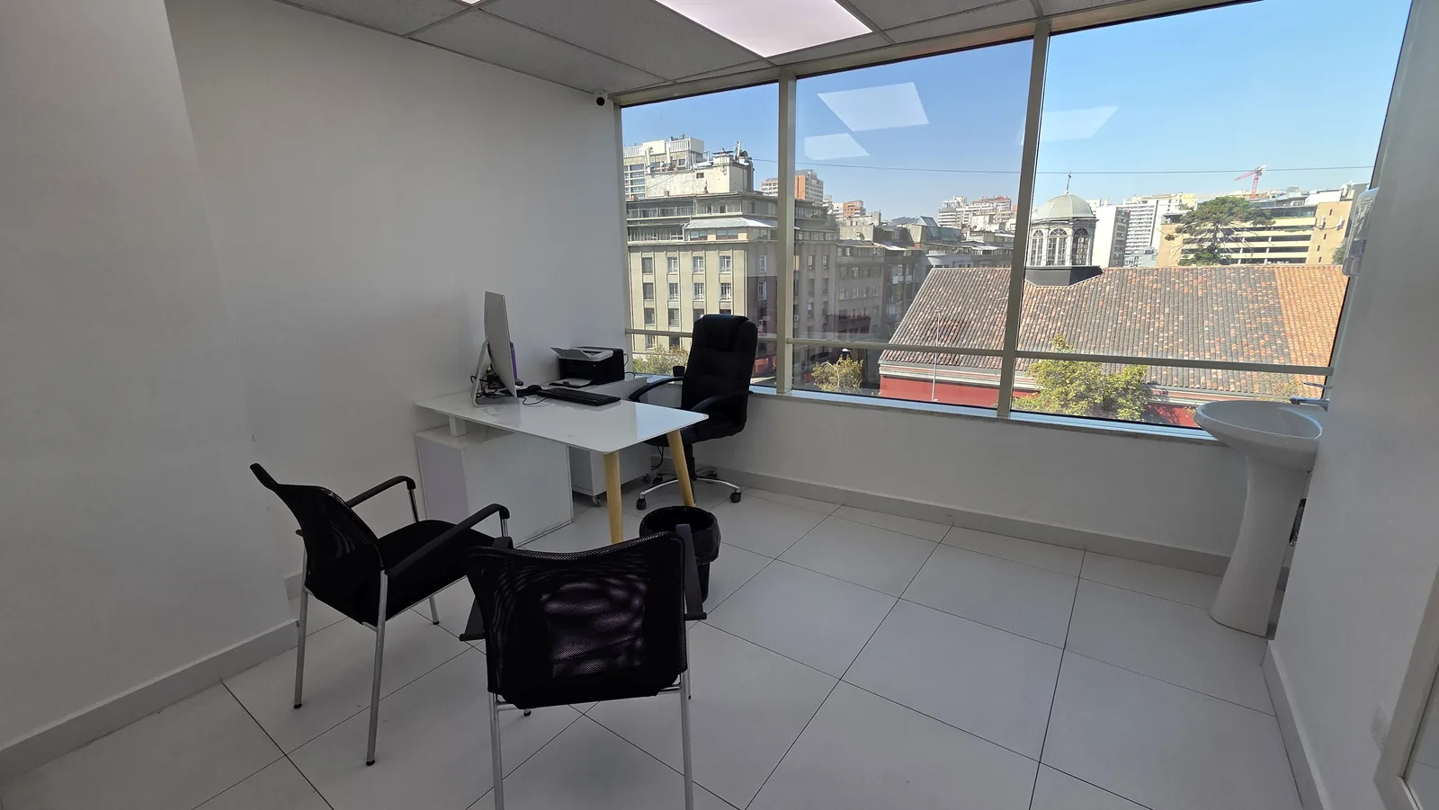 Box de atención con ventanal y vista a Santiago Centro