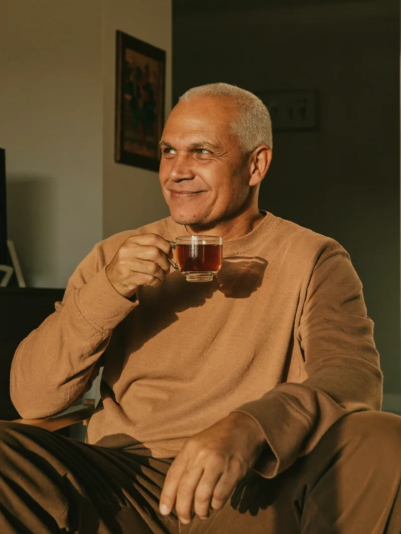 Un hombre toma una taza de té en su casa, tranquilo